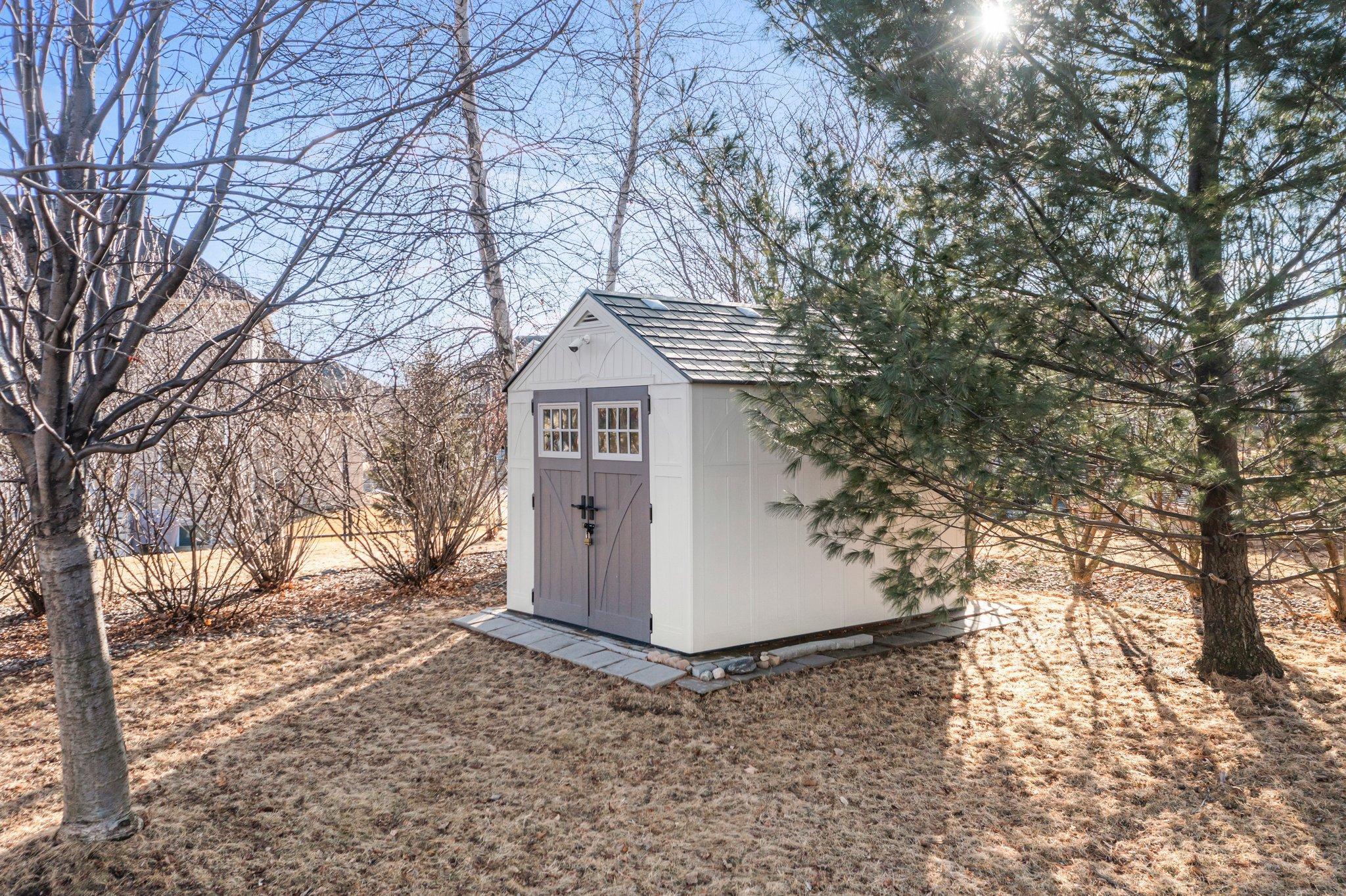 The convenient backyard shed offers additional storage space for outdoor tools and equipment.