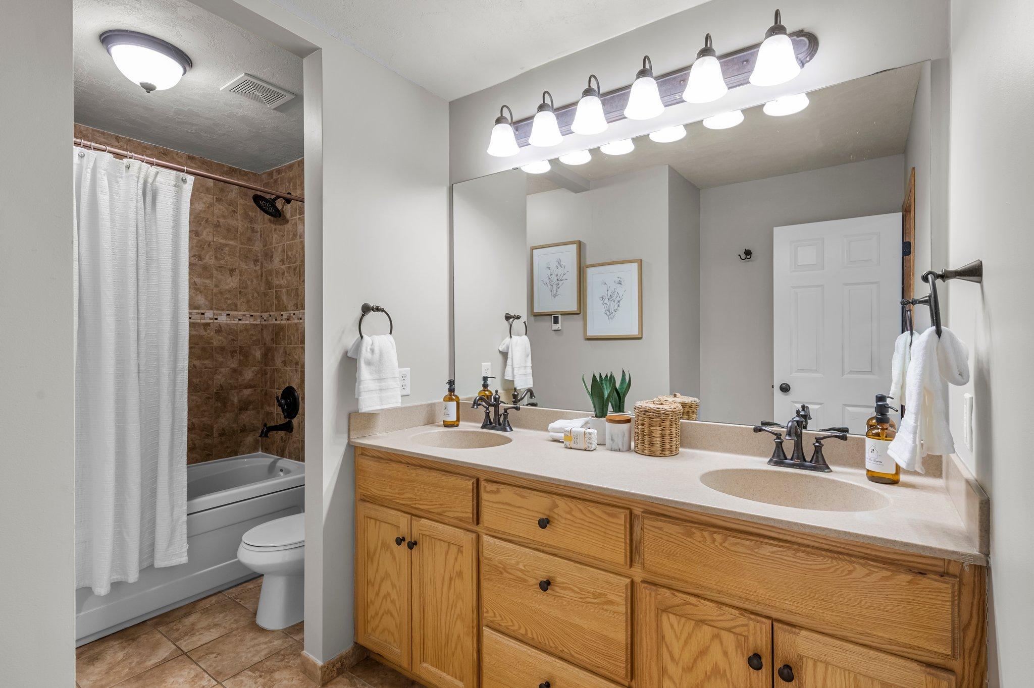 The private primary full bathroom includes heated floors, a shower and jetted tub combo perfect for relaxation, dual sinks with ample storage, and tile flooring.
