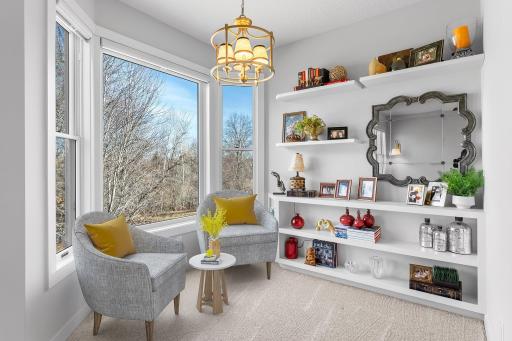 The sitting room in the primary bedroom has a bright bay window and built-in shelving.