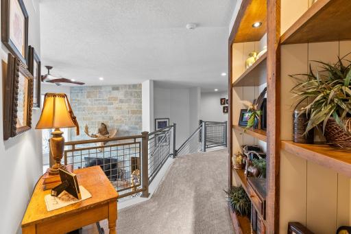 The upstairs hall leads to three bedrooms and two bathrooms.