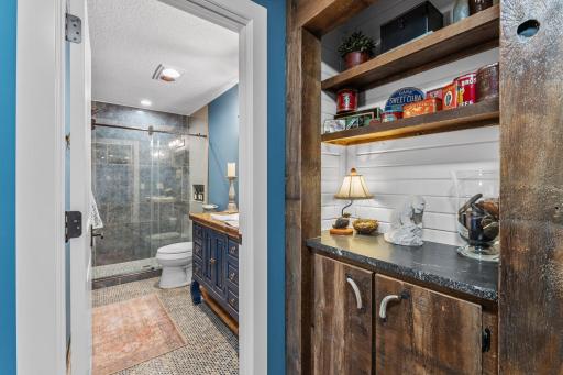 The lower level bathroom and a custom cabinet in the hall.