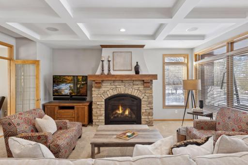 Stunning gas fireplace is the heart of the home complete with a coffered ceiling