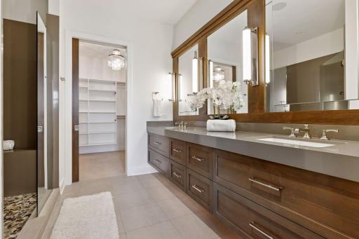 Beautifully appointed primary bath features dual sinks, oversized shower, great storage, and a large walk-in closet