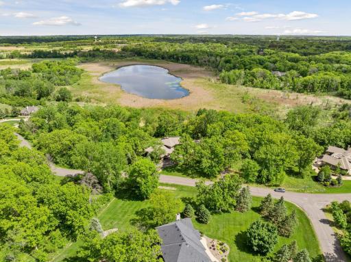 Aerial view - home in center on far side of road, with Black Lake in the background