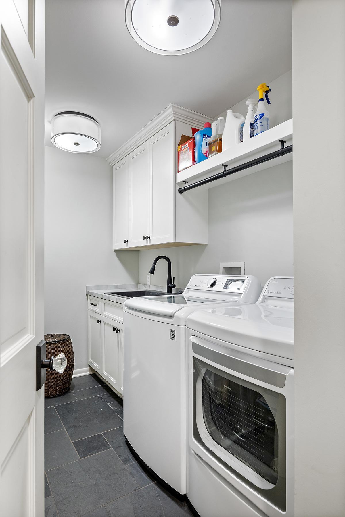 Newer washer/dryer, large sink shelving and cabinet storage.