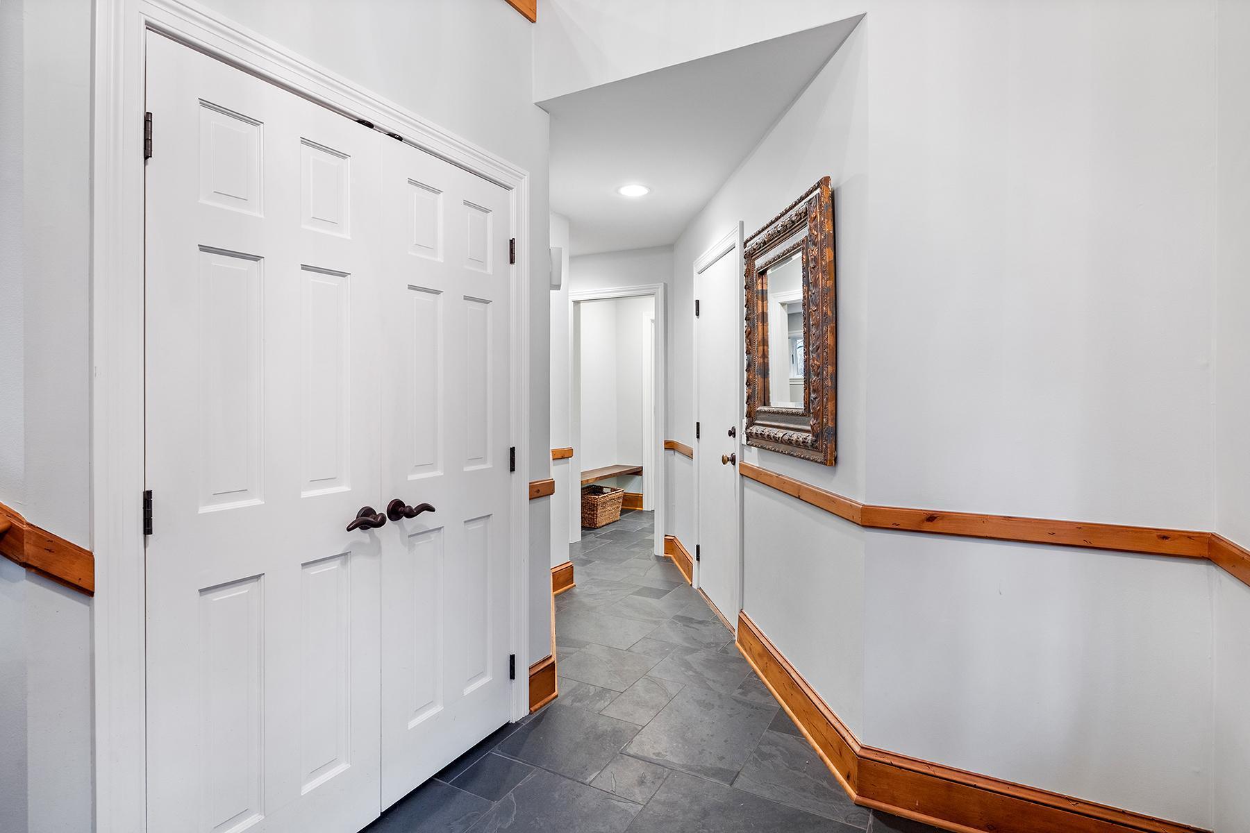 Large coat closet in foyer. Hall leading to to garage, mud and laundry rooms and half bath.