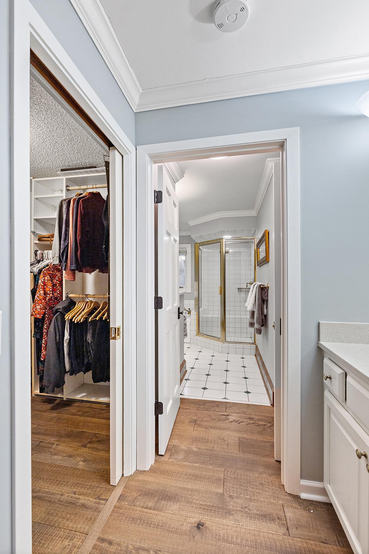 Walk-in closet with pocket doors, additional vanity and full bath in primary suite.
