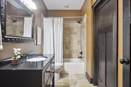 Fifth bedroom private ensuite bath features tile flooring and furniture style vanity