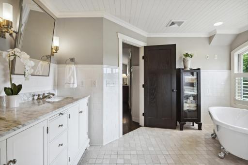 The spa-like owners' private bath features raised, dual vanity, shiplap ceiling detail and...
