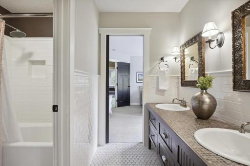 Full walk-thru bath between bedrooms 2 and 3 with dual vanity and separate room tub/shower with subway tile surround