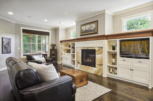 Welcoming, open floor plan features a spacious living room with a wall of built-ins and cozy gas fireplace