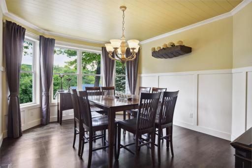 Separate formal dining room features wainscoting walls, shiplap ceiling and large bayed window filling the room with natural light. Doorway is framed to accommodate a door if desired.