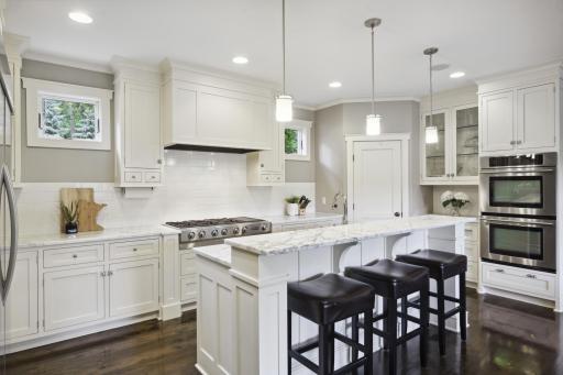 The kitchen is a delight for entertaining and offers ample prep and storage space with a walk-in pantry