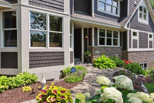Gorgeous perennial gardens border the paver walk to the front door