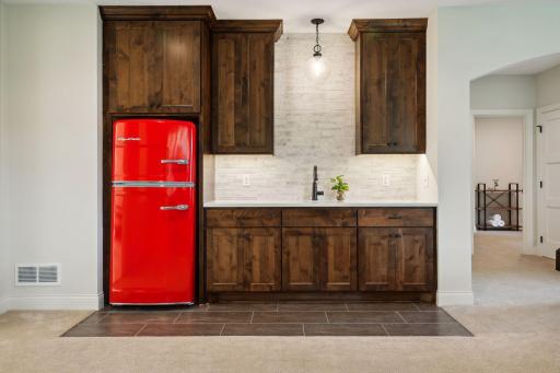 Wet bar with stone backsplash and knotty pine cabinetry