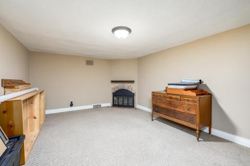 Large family room in lower level with cozy wood-burning fireplace.