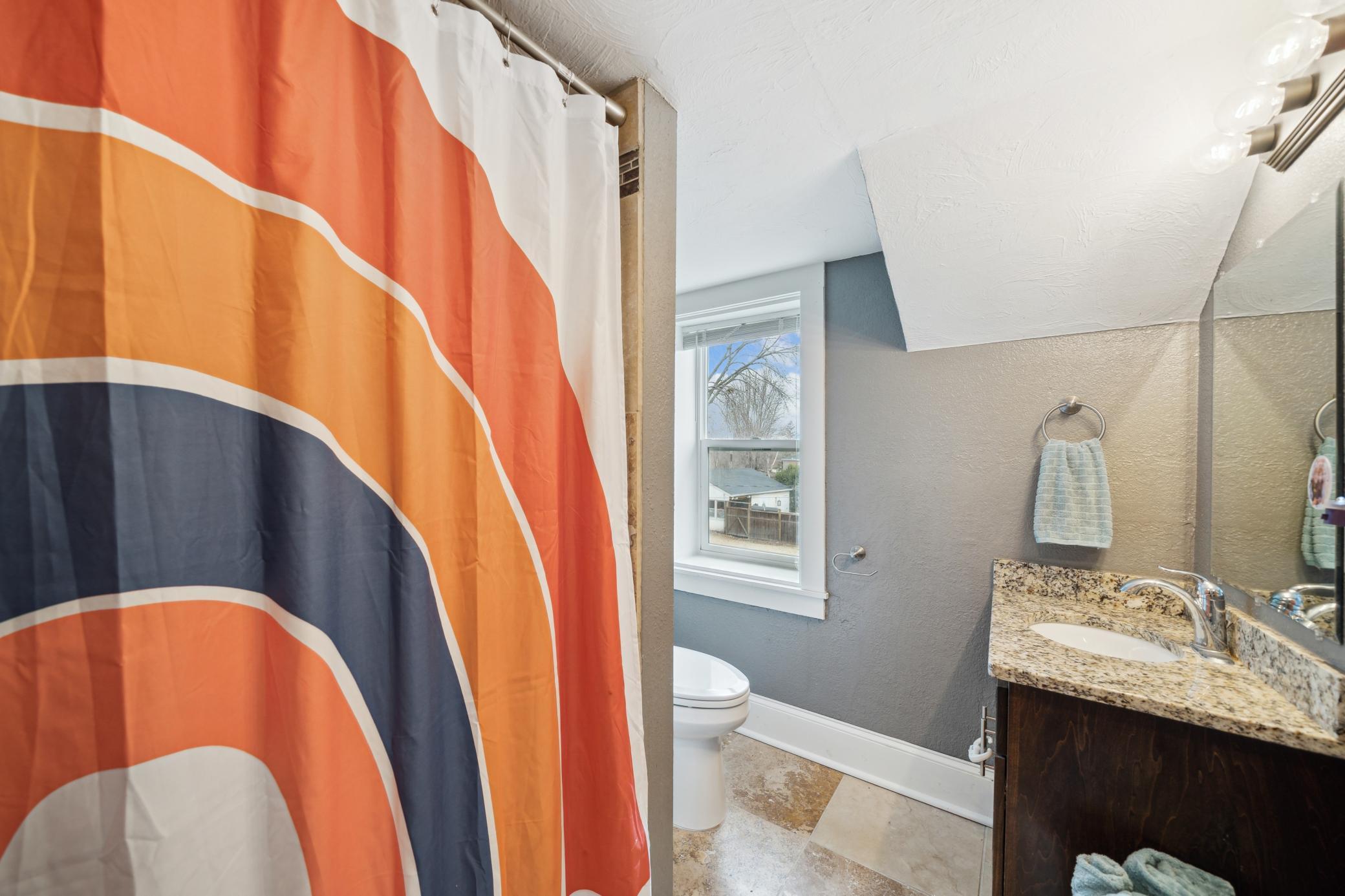 Upper level full bath with tiled floors and wood cabinet w/granite countertops