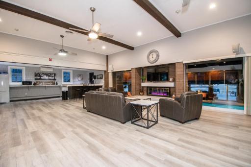 Renovated community room with fireplace, kitchen, and tables.