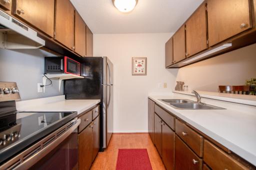 Crystal clean, galley style kitchen with stainless steel appliances including a dishwasher. NEW overhead light fixture, kitchen faucet and under cabinet lighting.