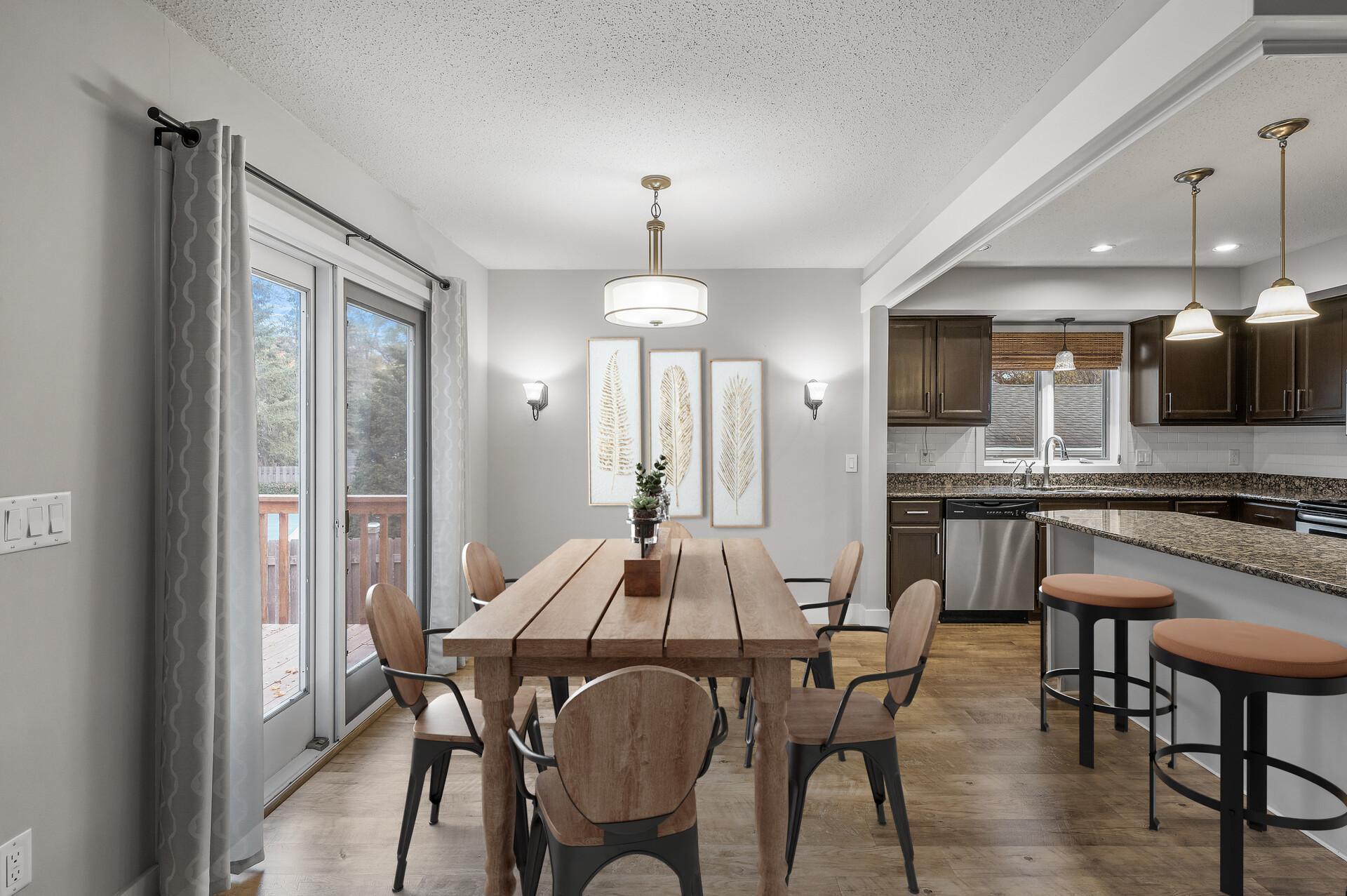 This informal dining room features trendy lighting and convenient deck access, making it a stylish and functional space for meals and gatherings.