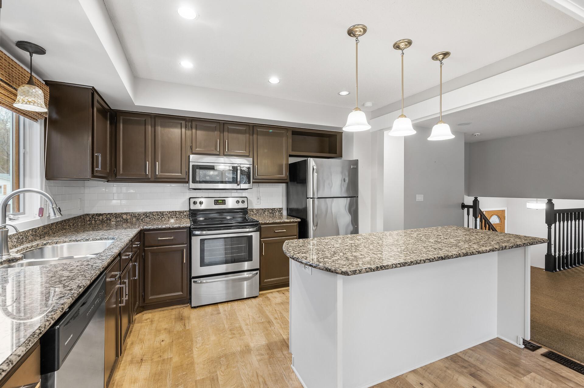 The kitchen boasts elegant granite countertops, stainless steel appliances, and a stylish subway tile backsplash