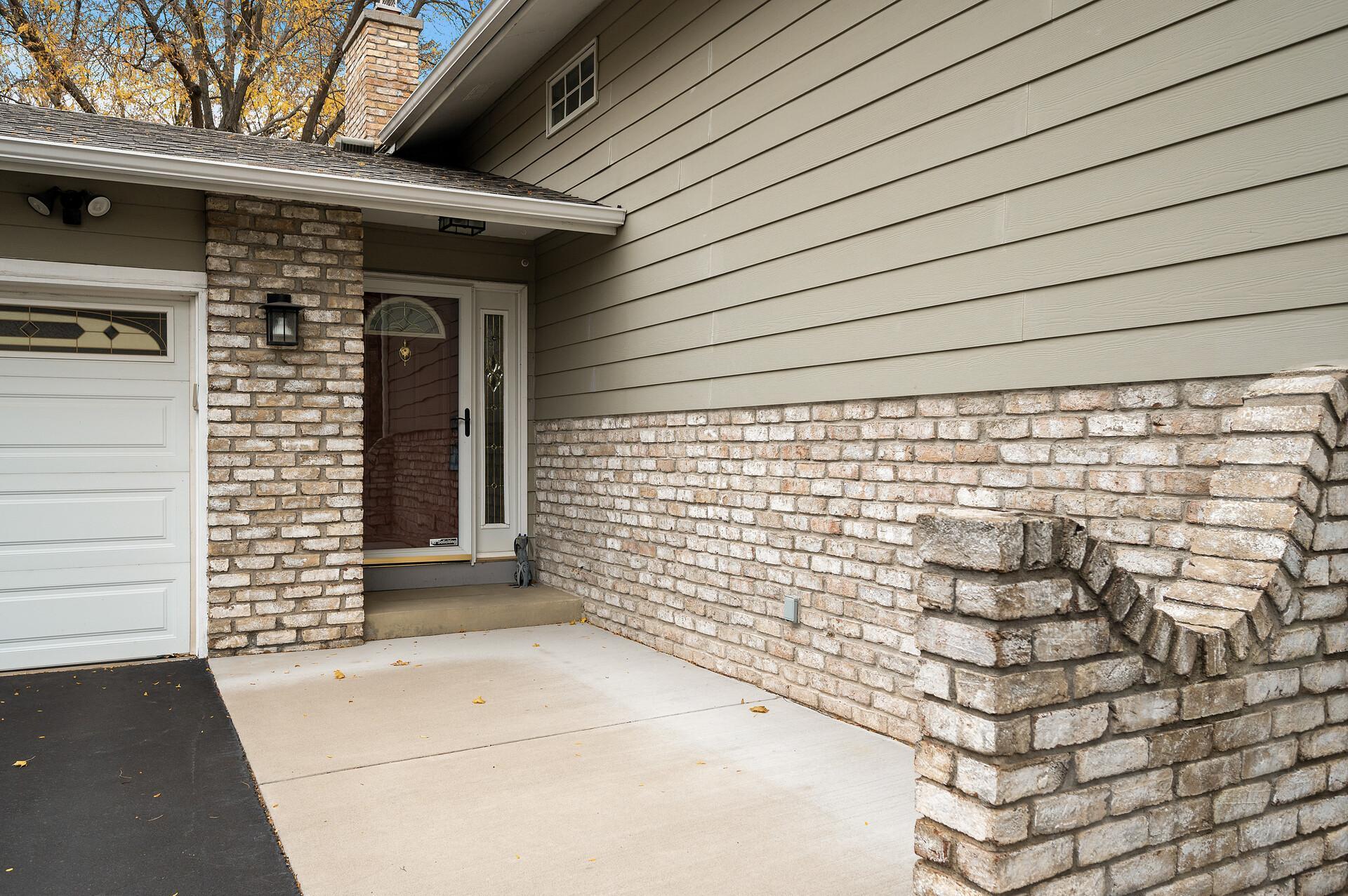 Welcoming concrete walkway with plenty of space for outdoor seating, perfect for relaxing or greeting guests in style.
