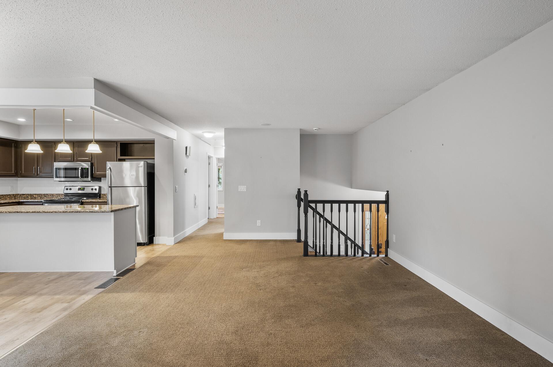 Here’s a view looking towards the hallway that leads to the full bath and two of the four spacious bedrooms, offering convenience and privacy for family and guests alike.