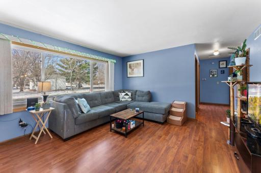 The bright and airy living room boasts large windows, allowing natural light to flood the space and create a warm, welcoming atmosphere.