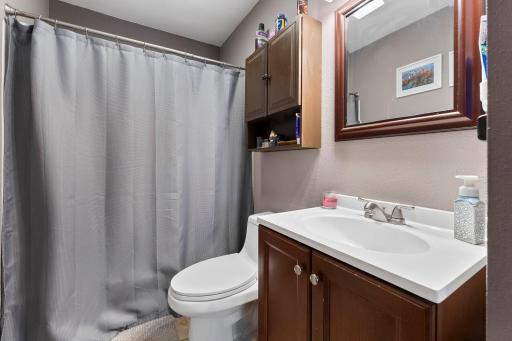This main-level full bath features a convenient tub and shower combination, offering both relaxation and functionality in one space.