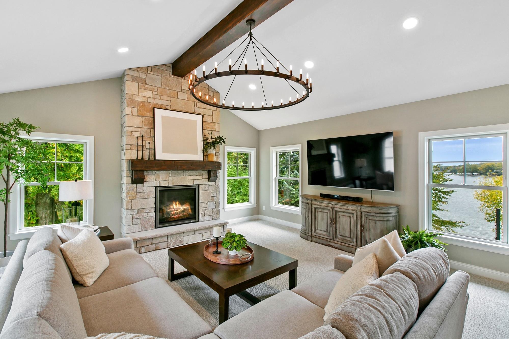 In the back of the home the sellers converted a three-season room to this cozy sunroom with a gorgeous stacked stone fireplace. Incredible lake views from the windows in this room!