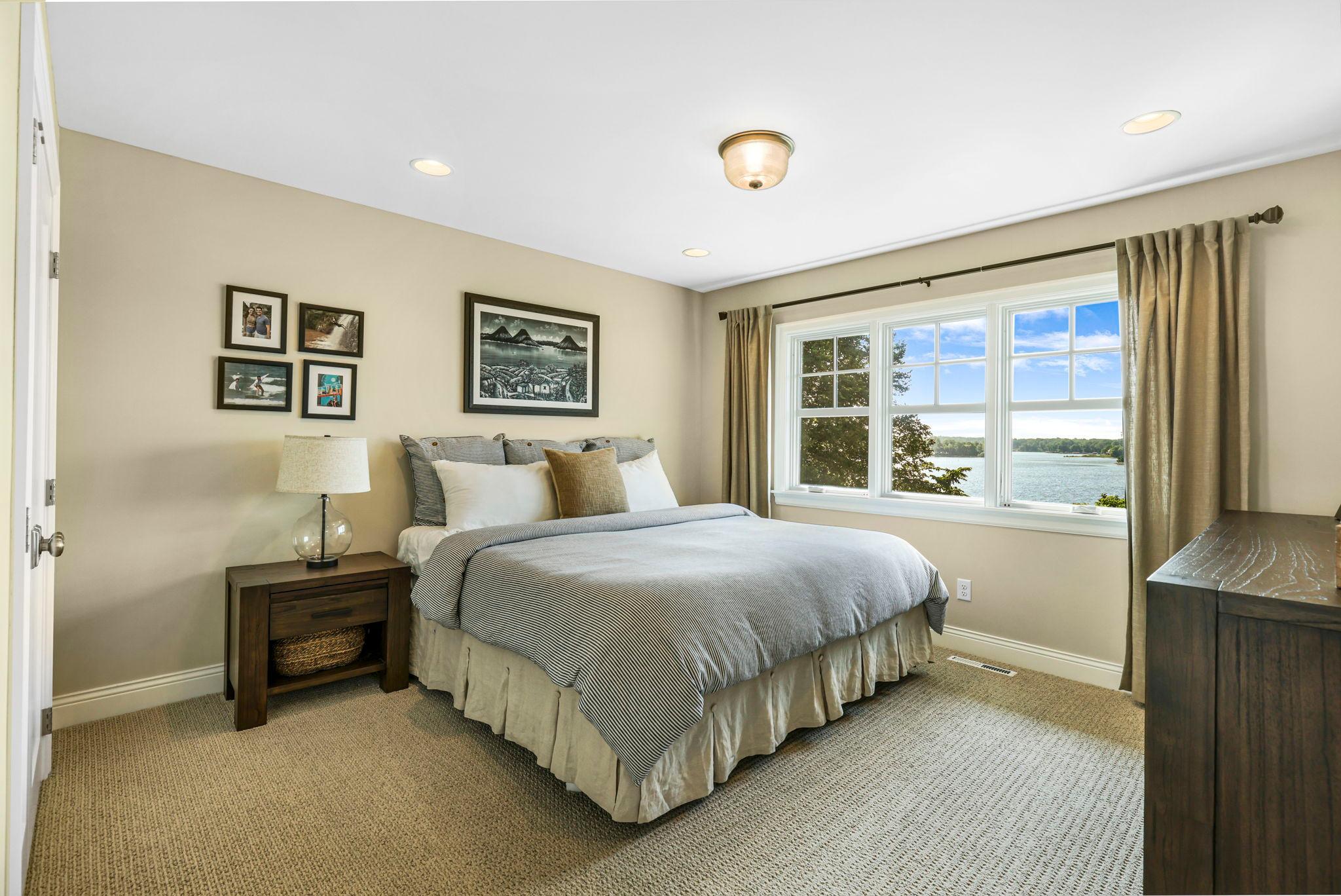 Bedroom two on the upper level looks out to the lake. All bedrooms have closet organizers in the closets.