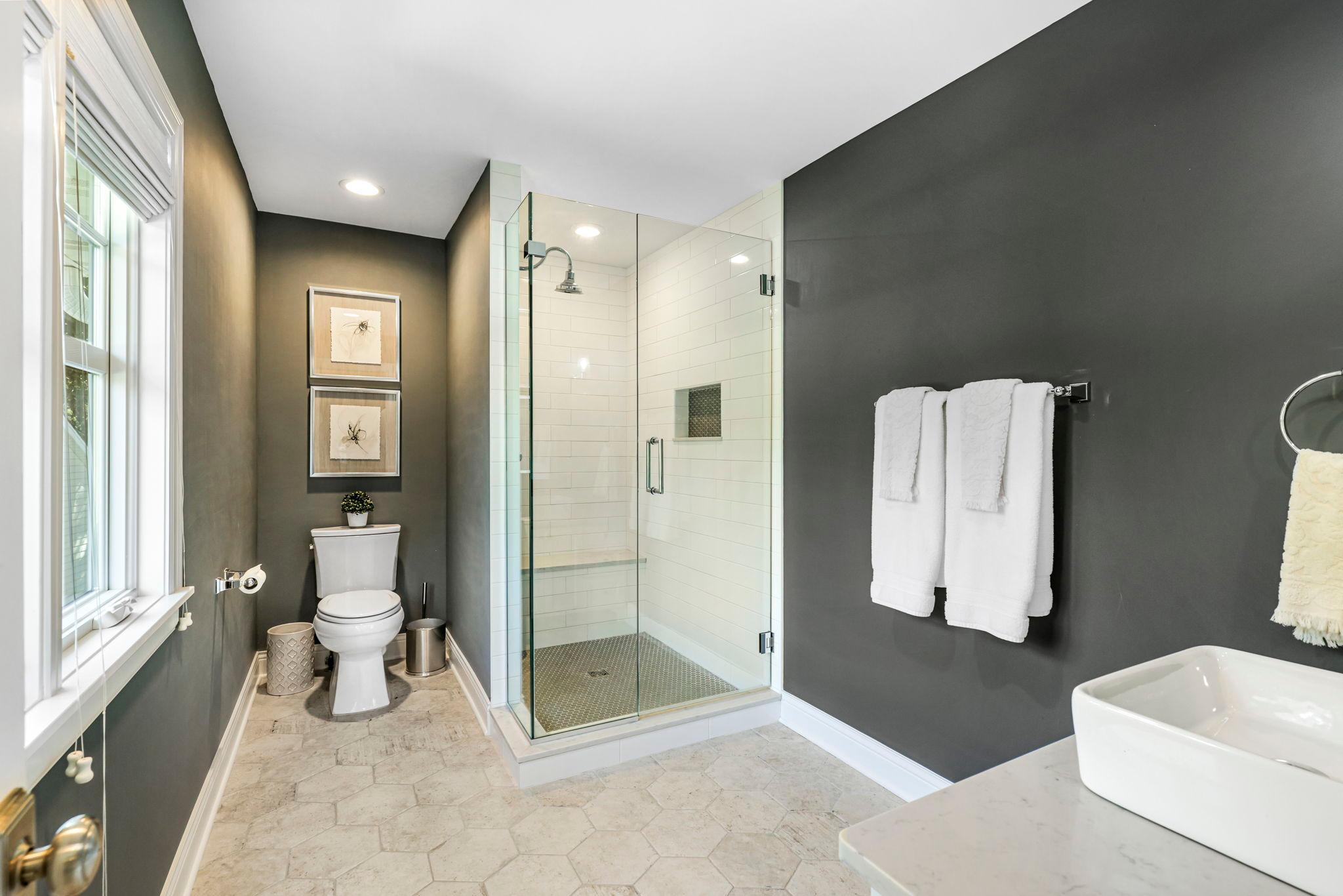 Another amazing bathroom that is attached to bedroom three features heated tiled flooring, quartz countertops and a large walk-in shower. All bathrooms have soft close drawers and doors.
