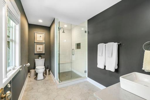 Another amazing bathroom that is attached to bedroom three features heated tiled flooring, quartz countertops and a large walk-in shower. All bathrooms have soft close drawers and doors.