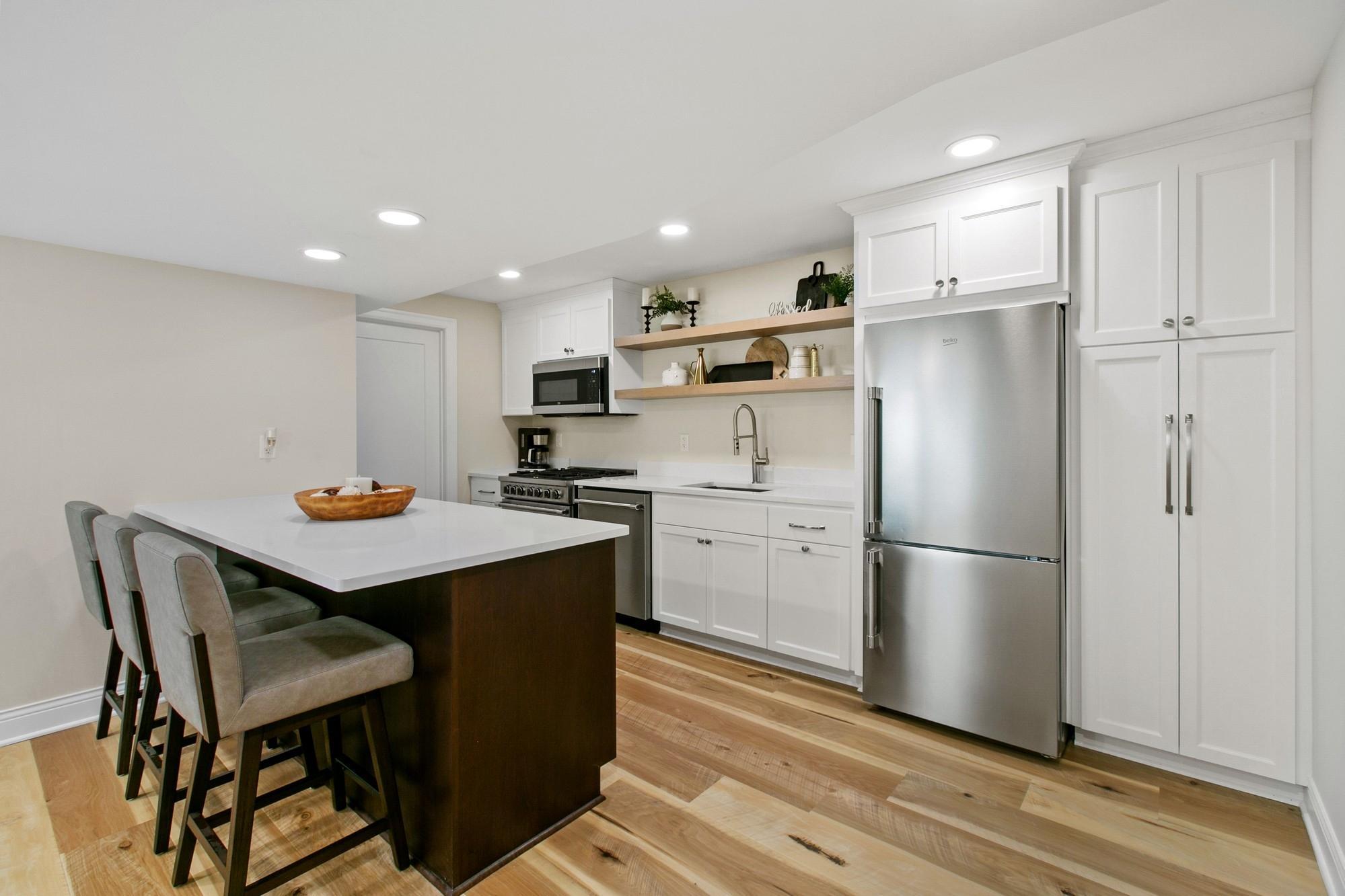 Retreat to the lower level where you'll find this second full kitchen with newer Beko appliances, beverage refrigerator, soft close cabinetry and an "island" for hosting parties.