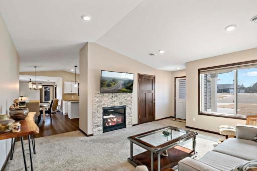 Beautiful vaulted ceilings and gas-burning stone fireplace accent this bright living room.