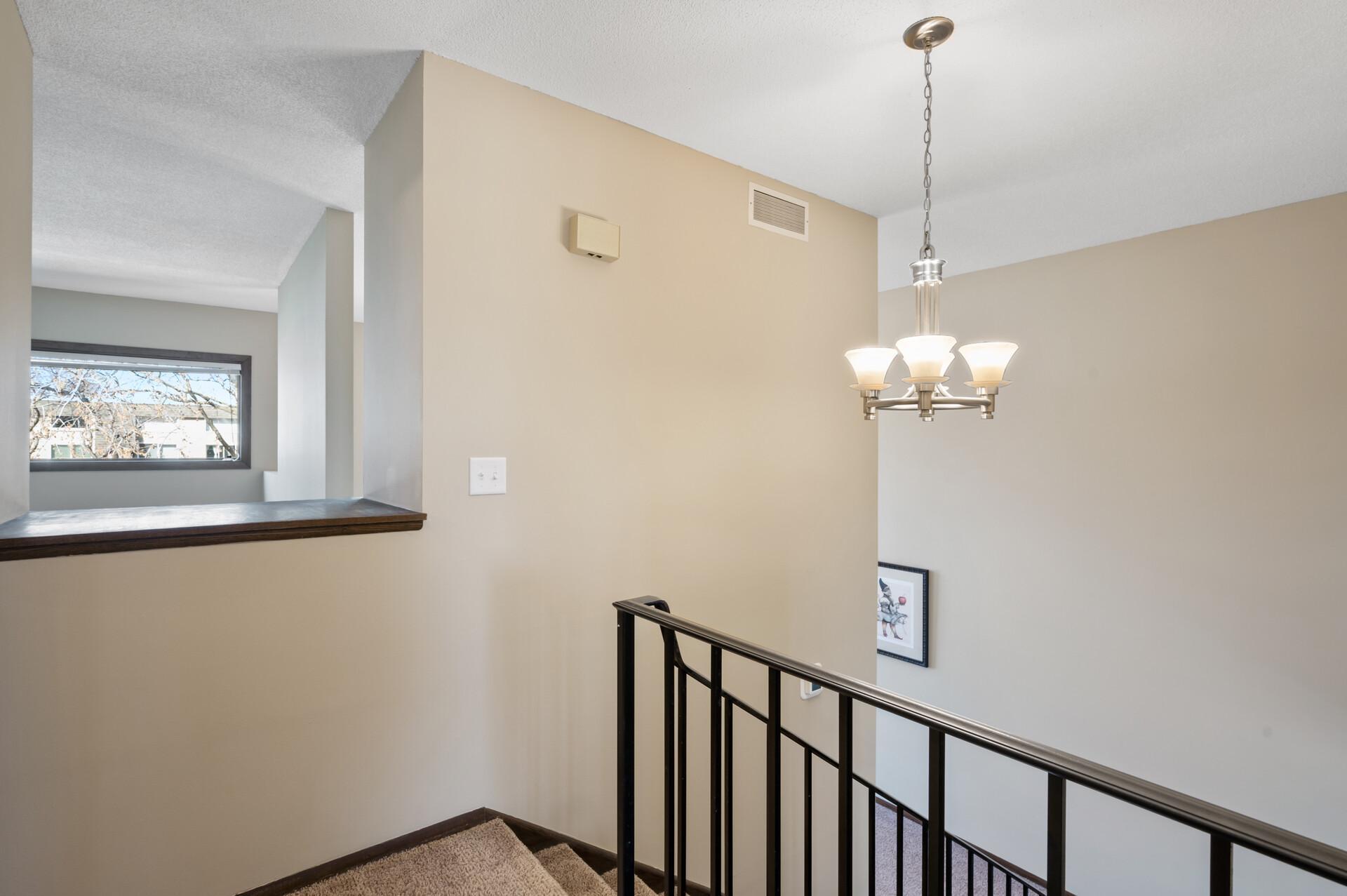 The natural light from the 2-story windows spills into the 3rd floor hallway with the opening that looks through to the kitchen and dining room.
