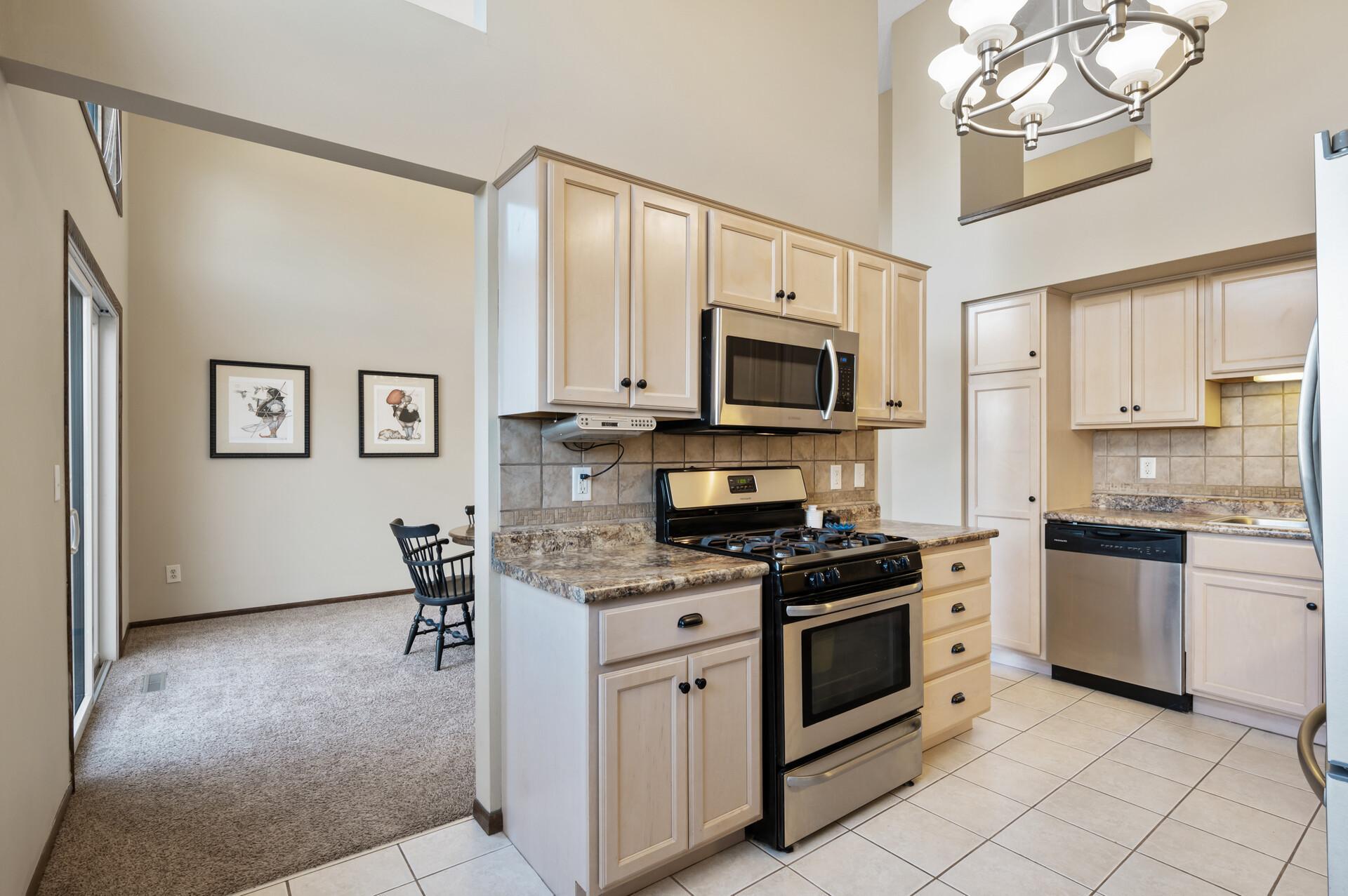 This kitchen features stainless steel appliances and ample cabinet space, including a pantry, which can be filled with snacks and kitchen staples.