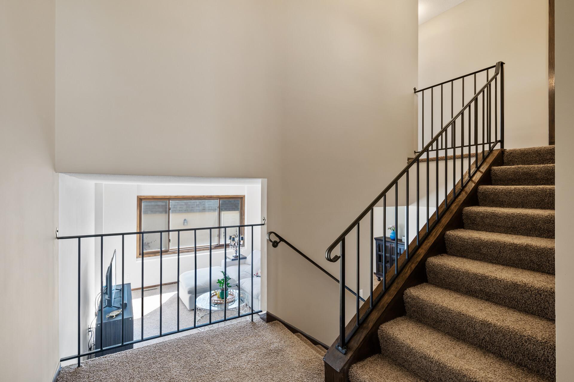 In this view you can see the split from the dining room with the stairs going up leading to the third level and an open railing looking into the main level living room.