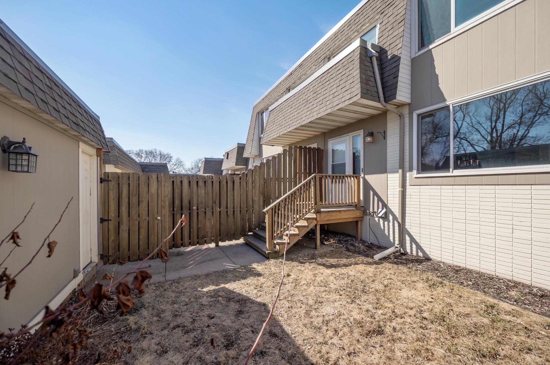 This reverse view shows the privacy fence with a gate for guest entry and the garage service door that leads directly to the home.