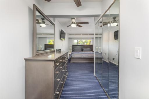 The hall is a dressing area and offers a large closet with mirrored doors.