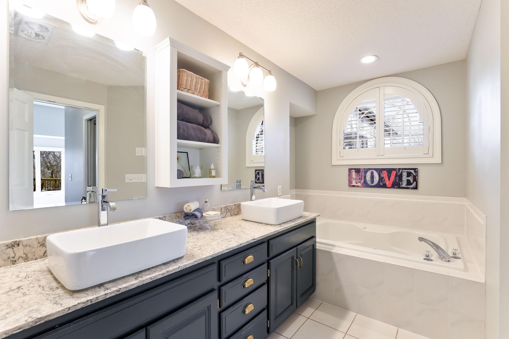 Primary bedroom full bathroom with dual vanity sinks