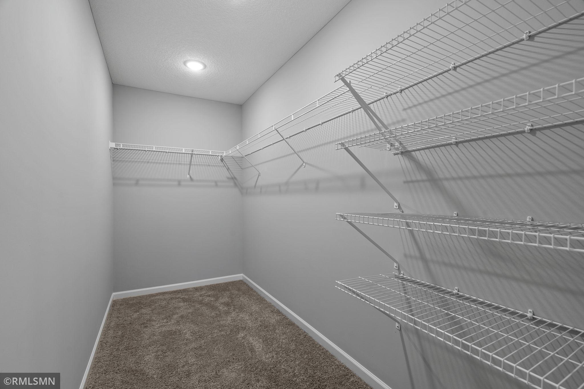 (Photo of previously finished home) A beautifully spacious walk-in closet, offering plenty of room to neatly organize your wardrobe, shoes, and accessories with ease.