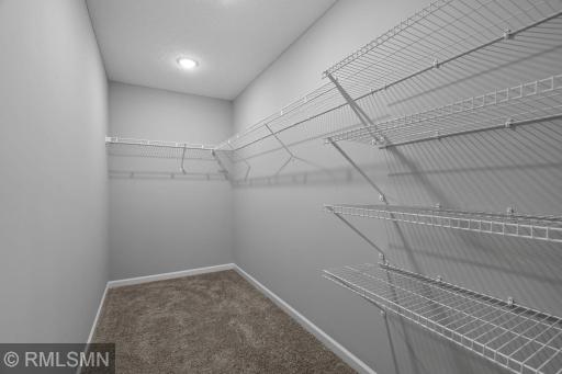 (Photo of previously finished home) A beautifully spacious walk-in closet, offering plenty of room to neatly organize your wardrobe, shoes, and accessories with ease.