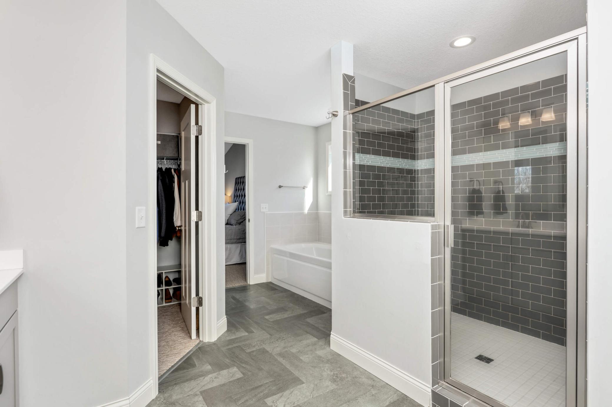 Walk-in tiled shower, separate tub, and huge closet.