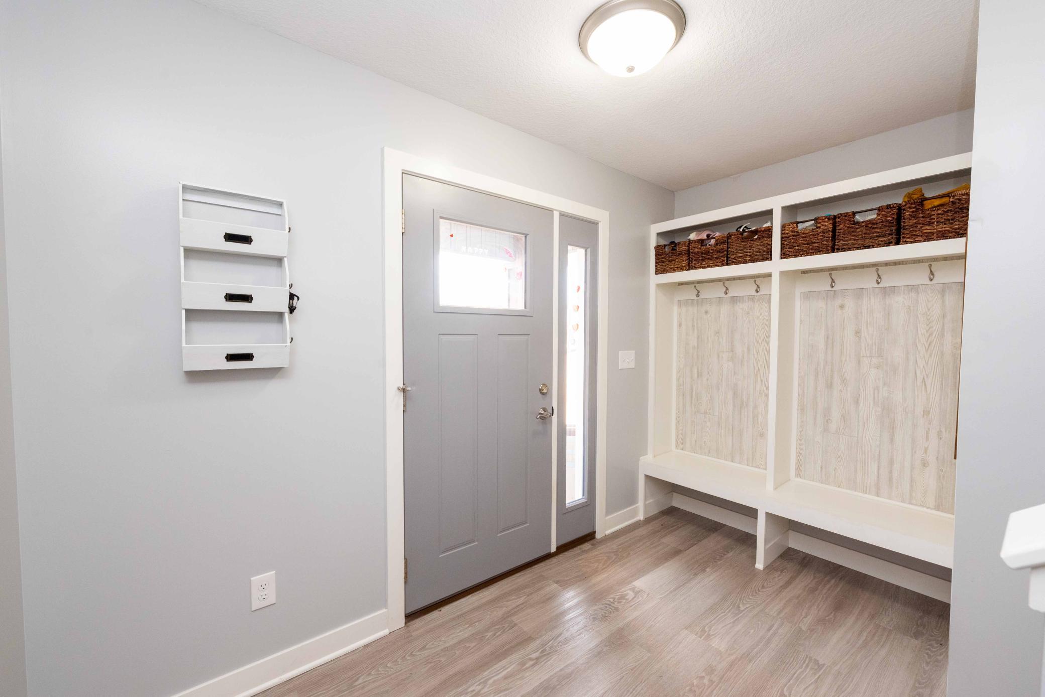Well designed entryway has bench for changing shoes and hangers for coats! Keeps things so organized Baskets hold hats/mittens/sports/etc.