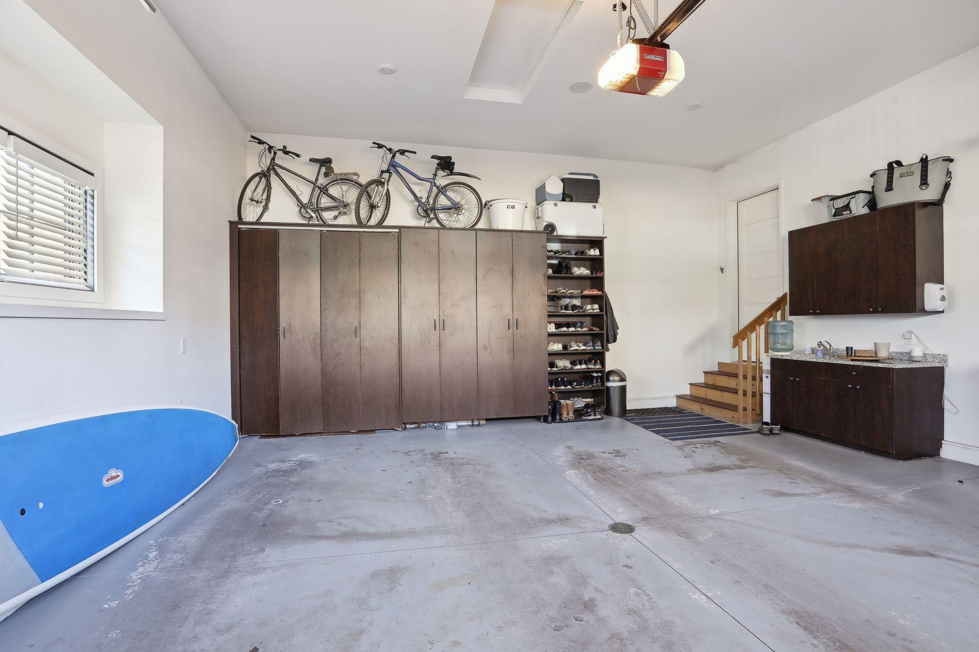 2 car attached heated garage with floor drain, reinforced garage floor, custom veneer built in cabinetry with very pretty utility sink and granite surround.