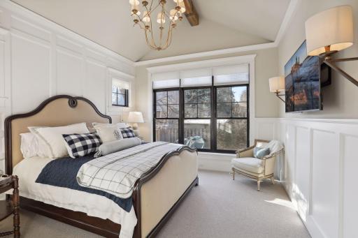 Main level Primary with vaulted, beamed ceiling and a private view of the backyard.