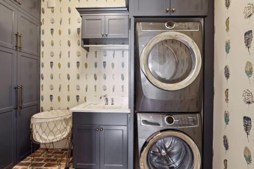 Main level laundry with "Old Chicago" brick floor and an abundance of storage. You'll love the utility sink, hanging rack and Electrolux stackable washer and dryer.