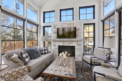Four season porch with heated "Old Chicago" brick flooring has a gas fireplace with Texas Cream Limestone surround and extension accents.