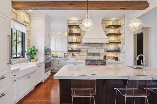 Enameled custom kitchen cabinetry with floating walnut shelving make this kitchen bright, current and sophisticated!